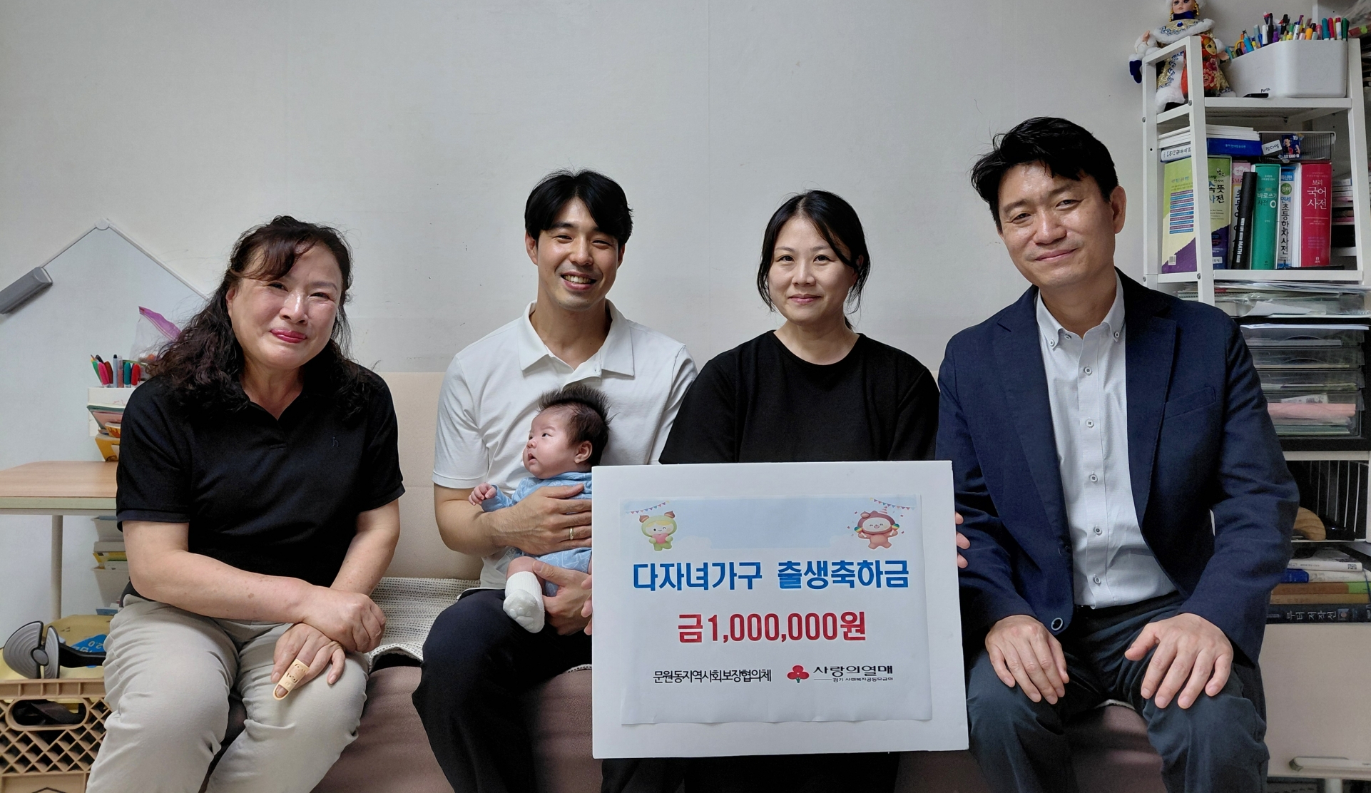문원동지역사회보장협의체가 '나눔가게' 후원금으로 마련한 출산지원금 100만 원을 여섯째 아이를 출산한 가정에 전달한 뒤 기념촬영을 하고 있다